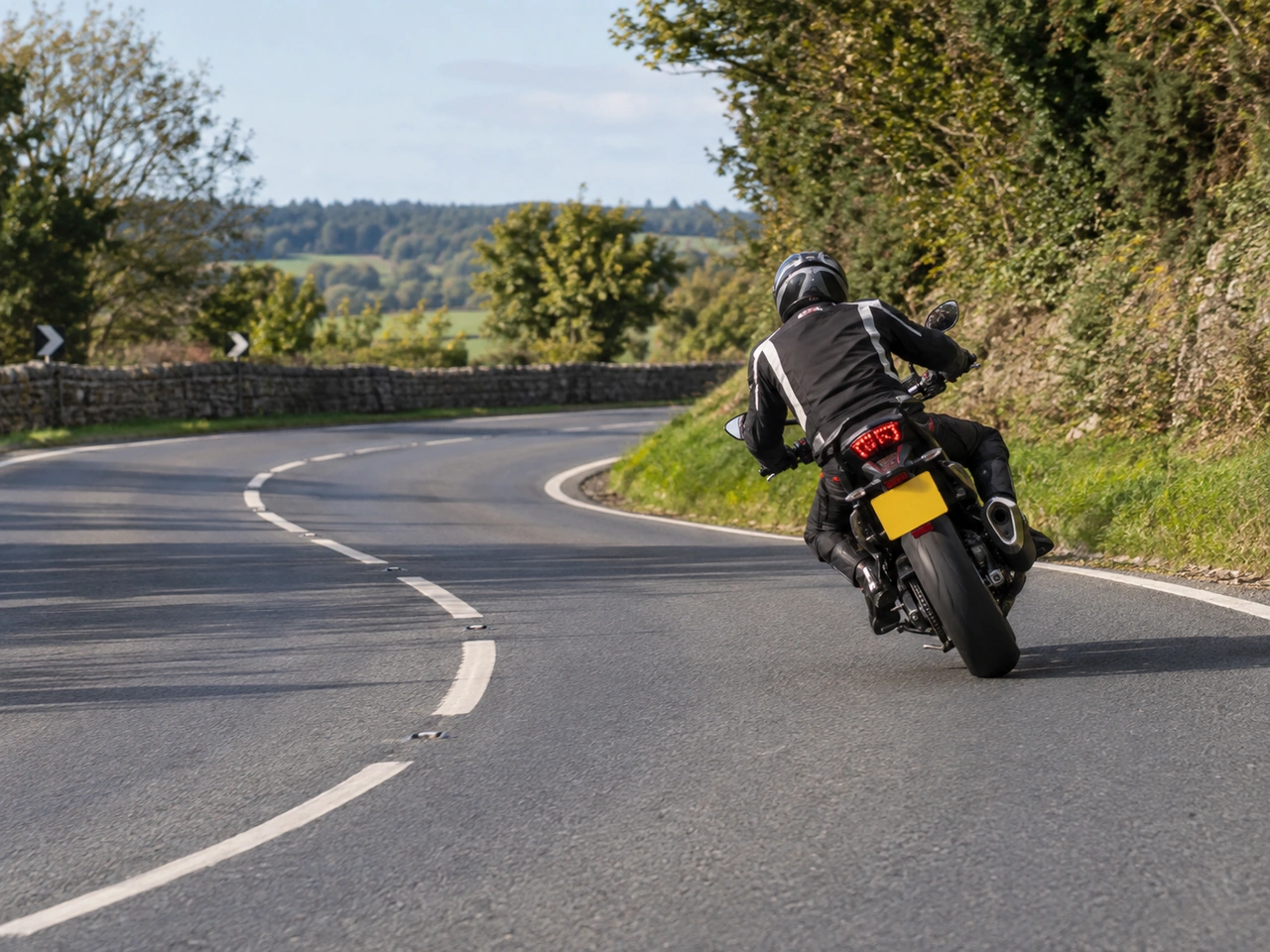 Porque deve evitar travagens fortes enquanto o motociclo está inclinado numa curva?
