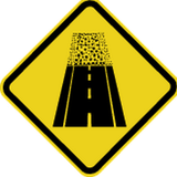 Warnung vor unbefestigter Fahrbahn.
