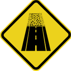 Warnung vor unbefestigter Fahrbahn.