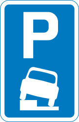Estacionamento parcialmente na faixa de rodagem e berma.