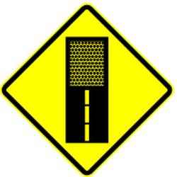 Warning for an unpaved road surface.