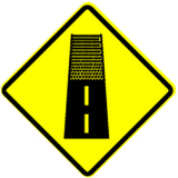Warning for an unpaved road surface.