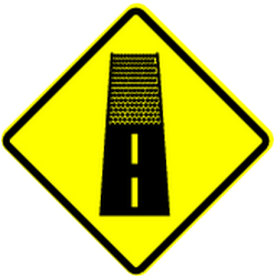 Warning for an unpaved road surface.