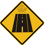 Warnung vor unbefestigter Fahrbahn.