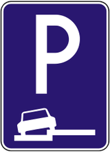 Estacionamiento parcialmente en calzada y arcén.